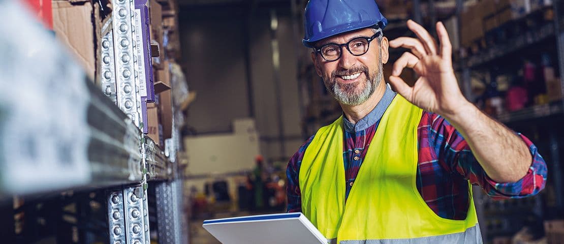 Mitarbeiter im Lager bei stehender Tätigkeit als Beispiel für ergonomisches Arbeiten am Arbeitsplatz