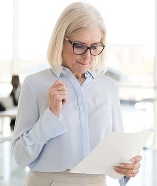 Frau wirkt nervös und liest Notizen als Beispiel für Lampenfieber vor einem Vortrag