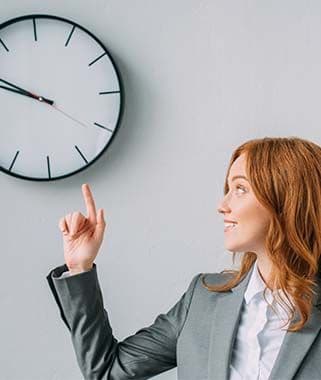 Frau zeigt auf eine Uhr als Symbol für Zeitmanagement bei Präsentationen