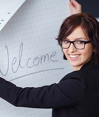 Frau erklärt Inhalte am Whiteboard während eines Vortrags