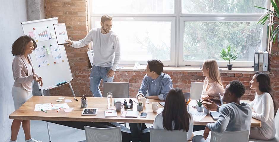 Teammeeting im Büro während einer Präsentation an einem Whiteboard